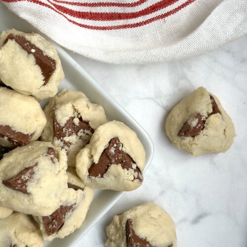 A platter of Toblerone shortbread cookies is seen from above on a white marble table