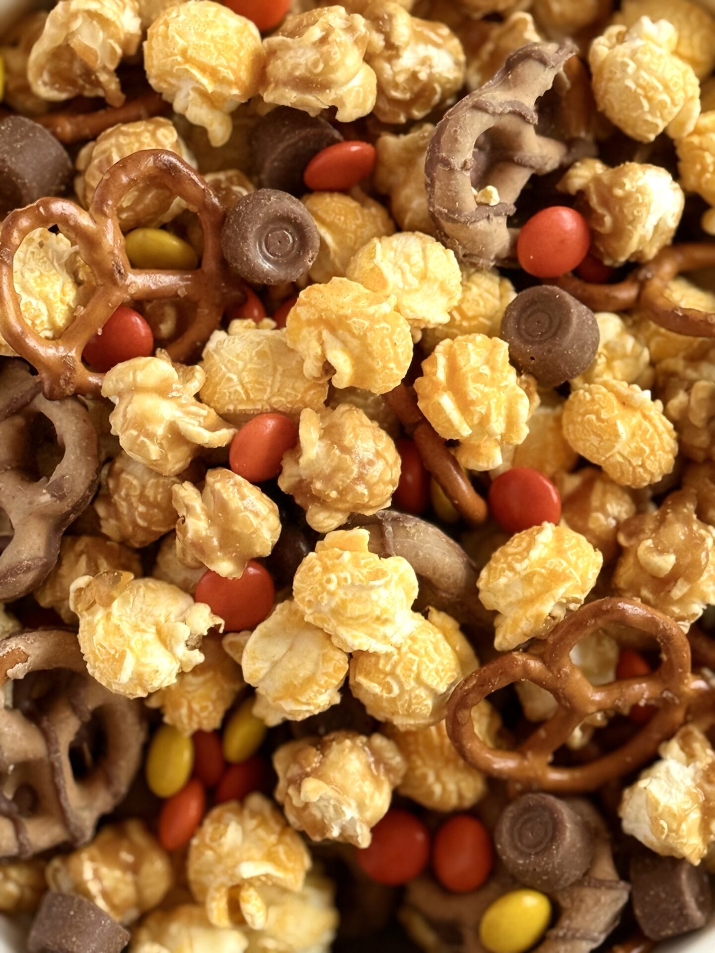 Popcorn, pretzels, chocolates and candies are mixed together in Monster Munch Halloween Snack Mix.  