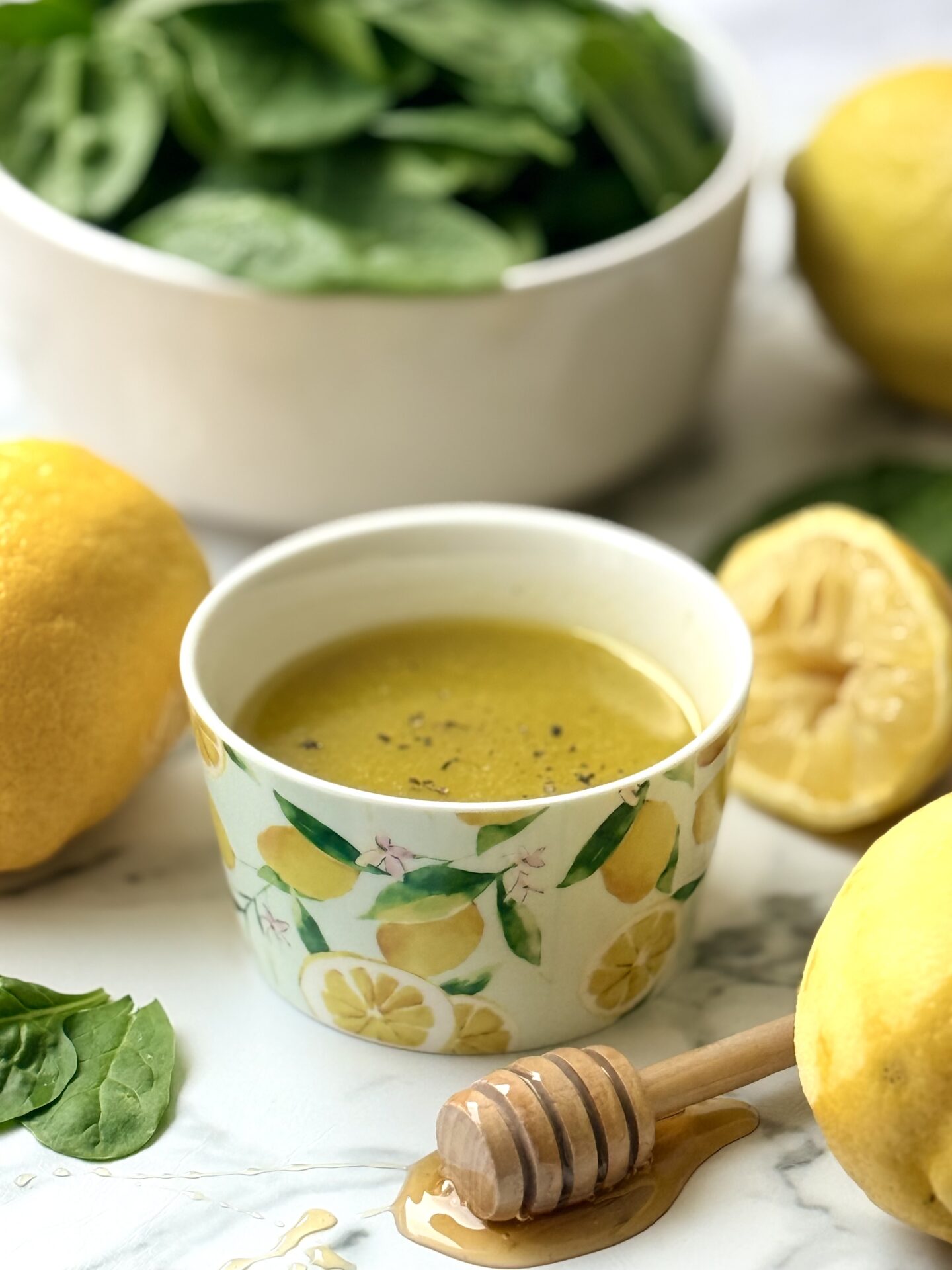 A small dish with a lemon pattern contains a bright yellow lemon vinaigrette.