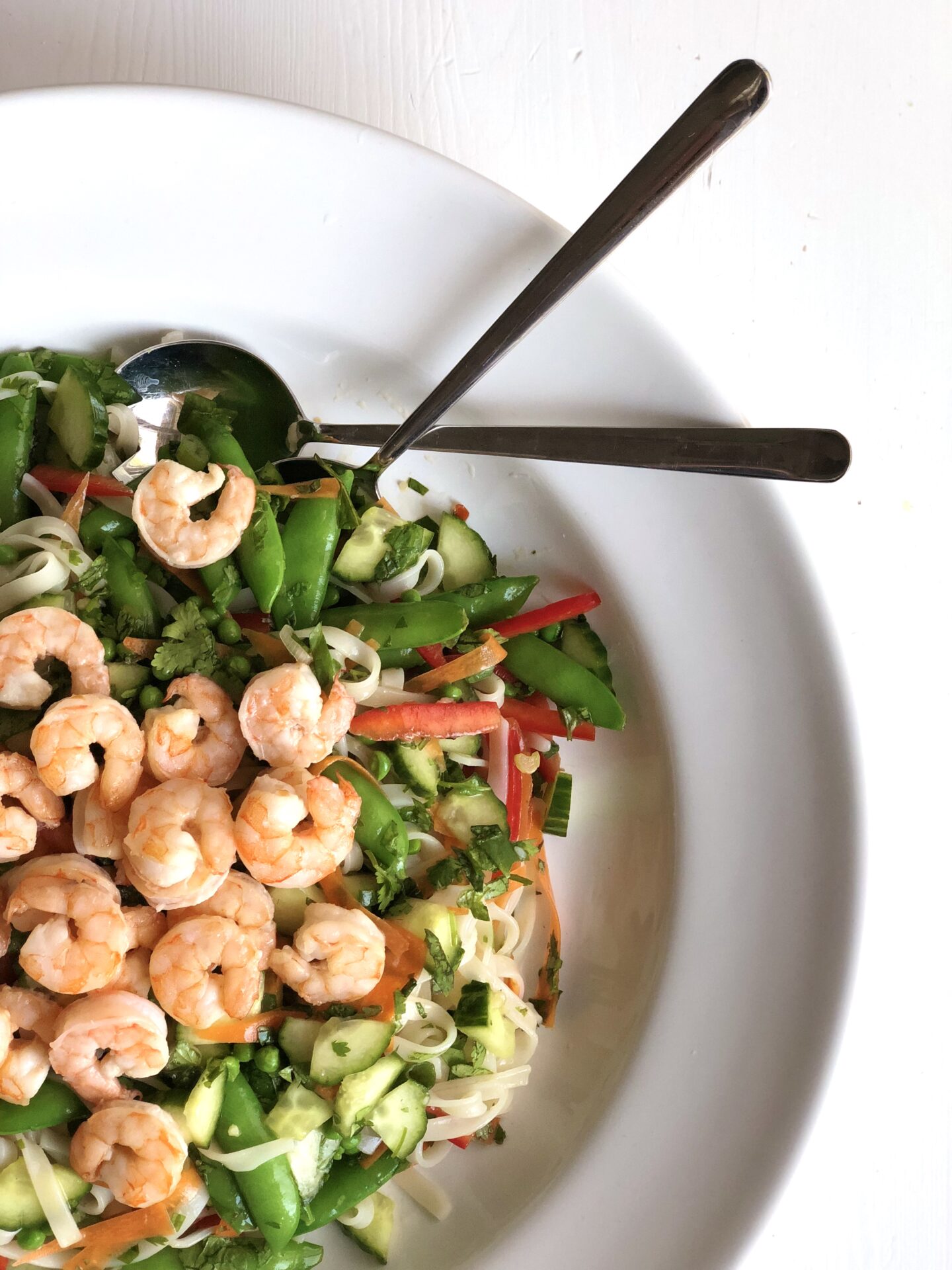 Thai noodle salad with vegetables, fresh herbs and roasted shrimp seen from above