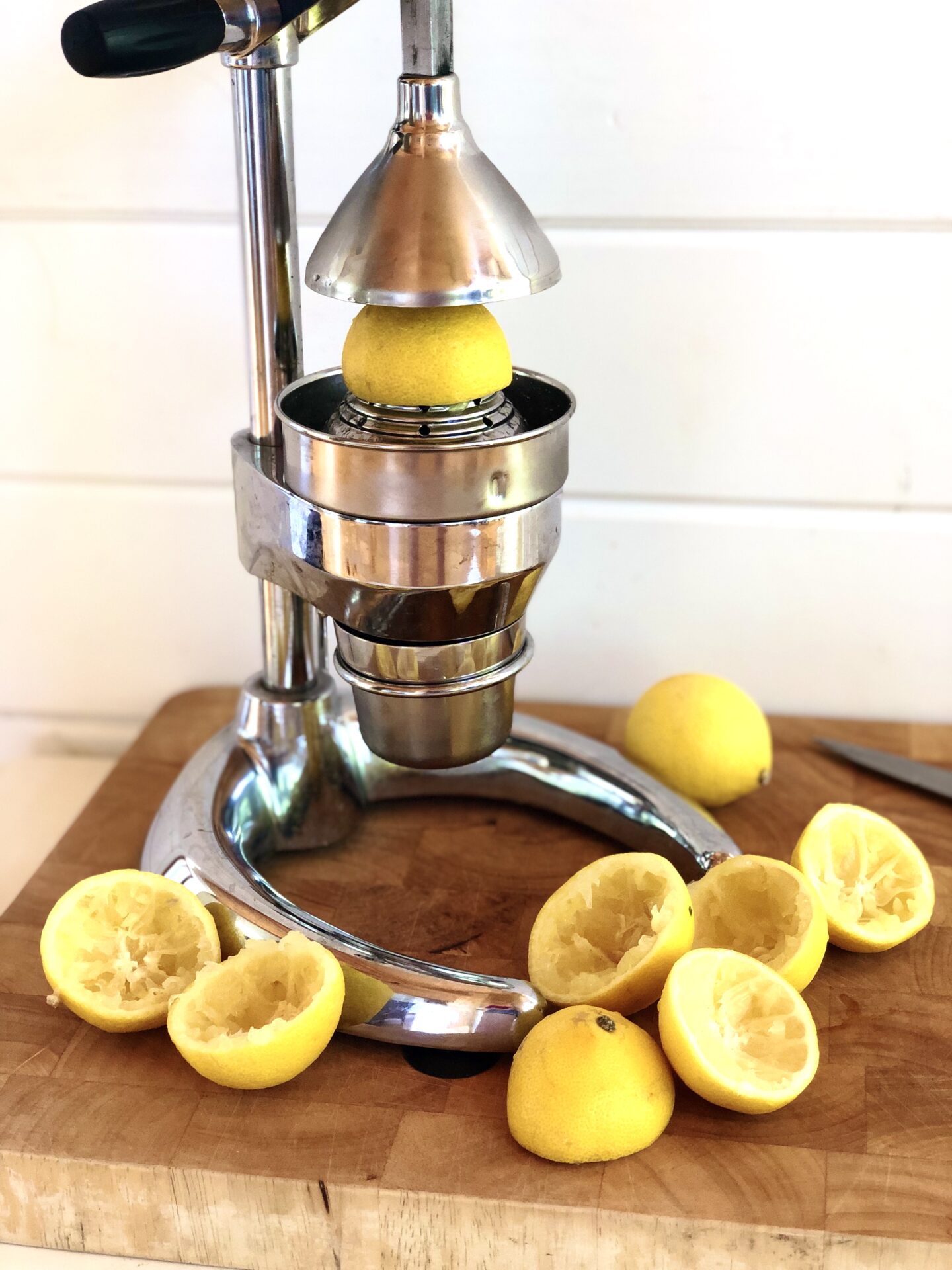 Citrus press with lemon rinds on a butchers block