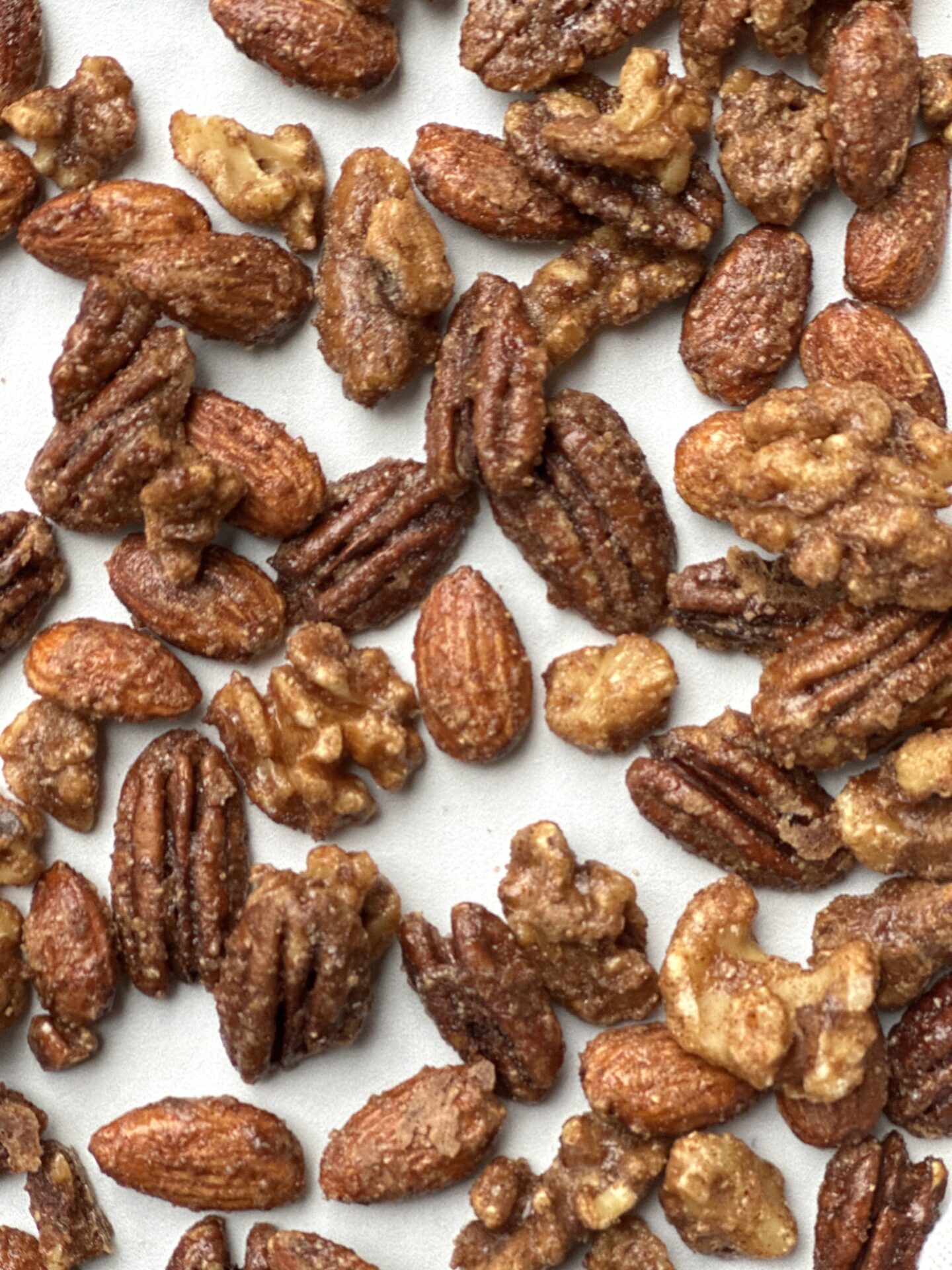 Recipe for homemade sweet and spicy pecans walnuts and almonds on a baking sheet, a perfect appetizer for your holiday party