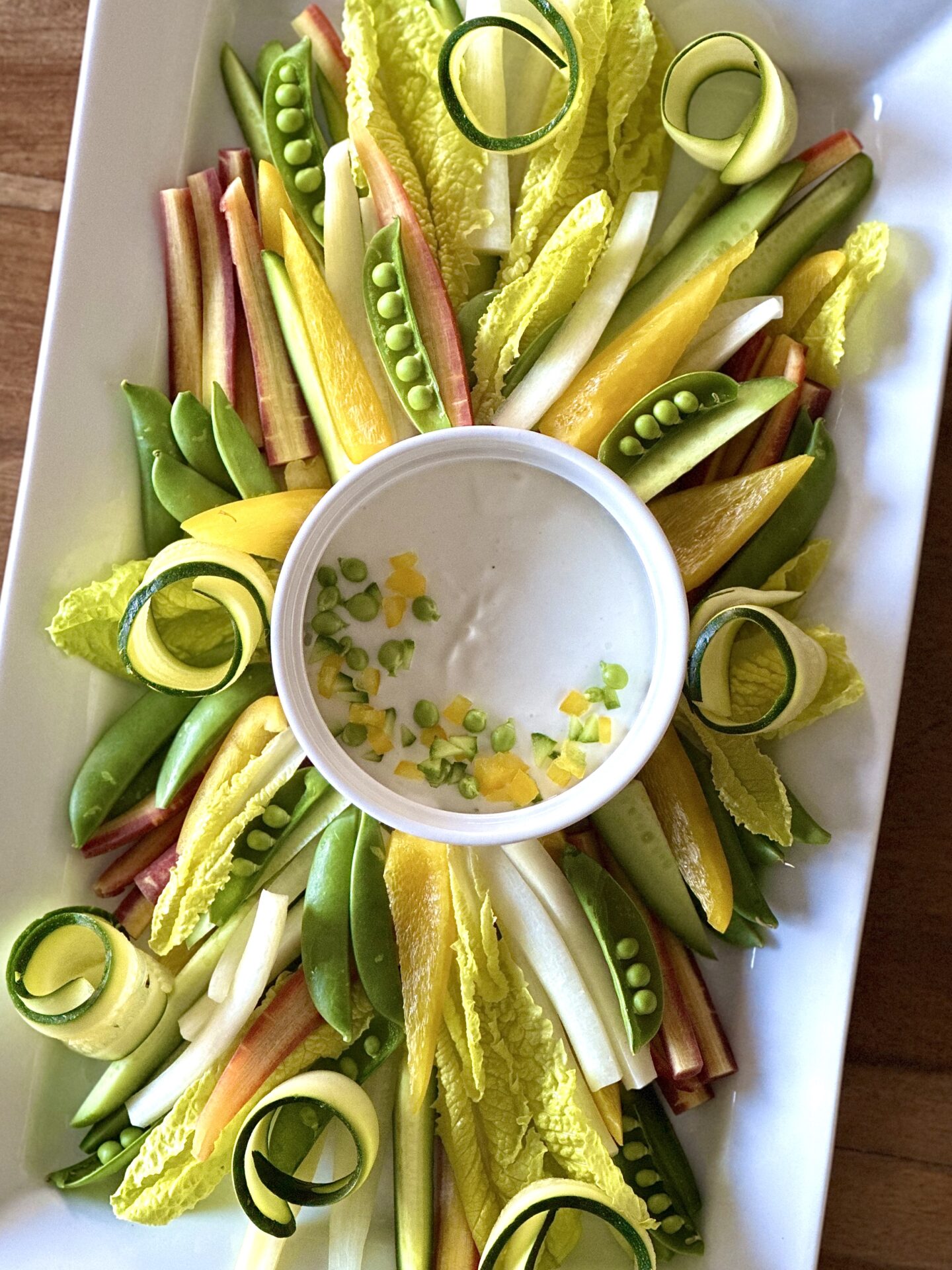 Beautiful platter of fresh spring crudité with light and creamy lemon dip