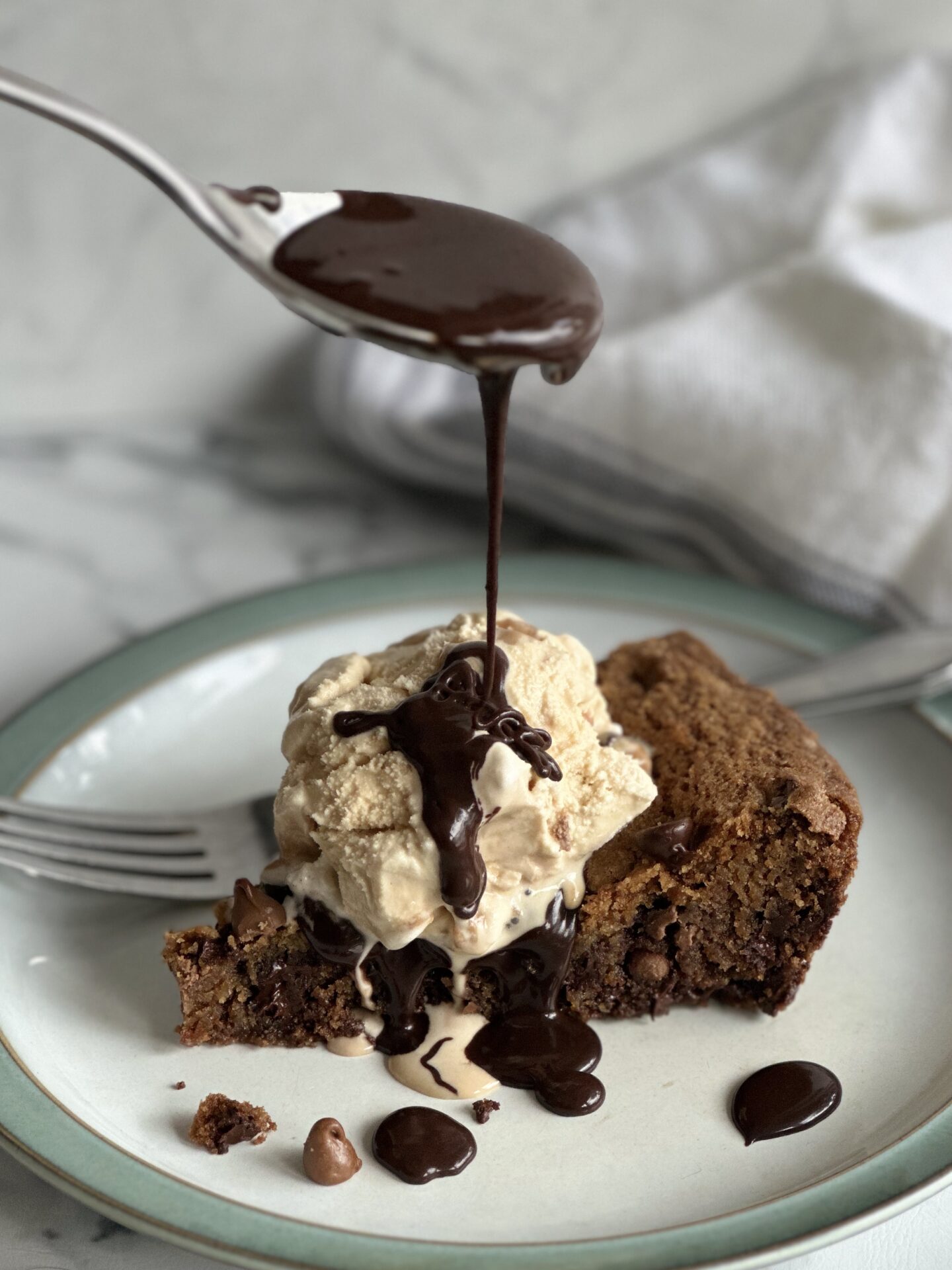 Hot Fudge sauce being spooned over cake and ice cream