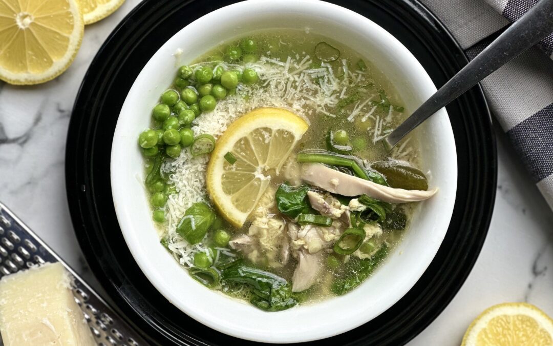 Bowl of Spring Straciatella Soup seen from above with fresh basil, lemon and parmesan cheese