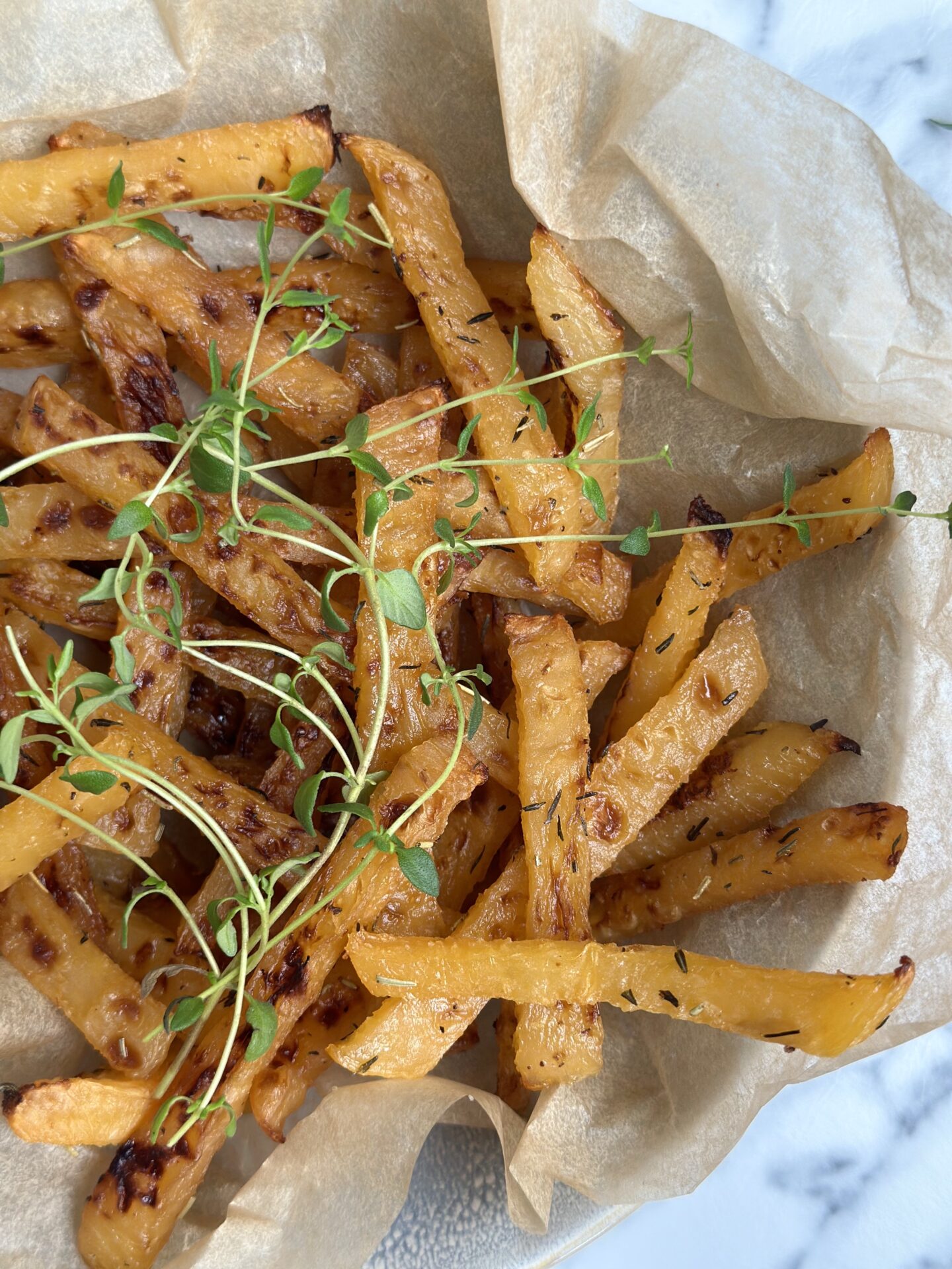 Oven roasted rutabaga fries seen from above, garnished with fresh thyme