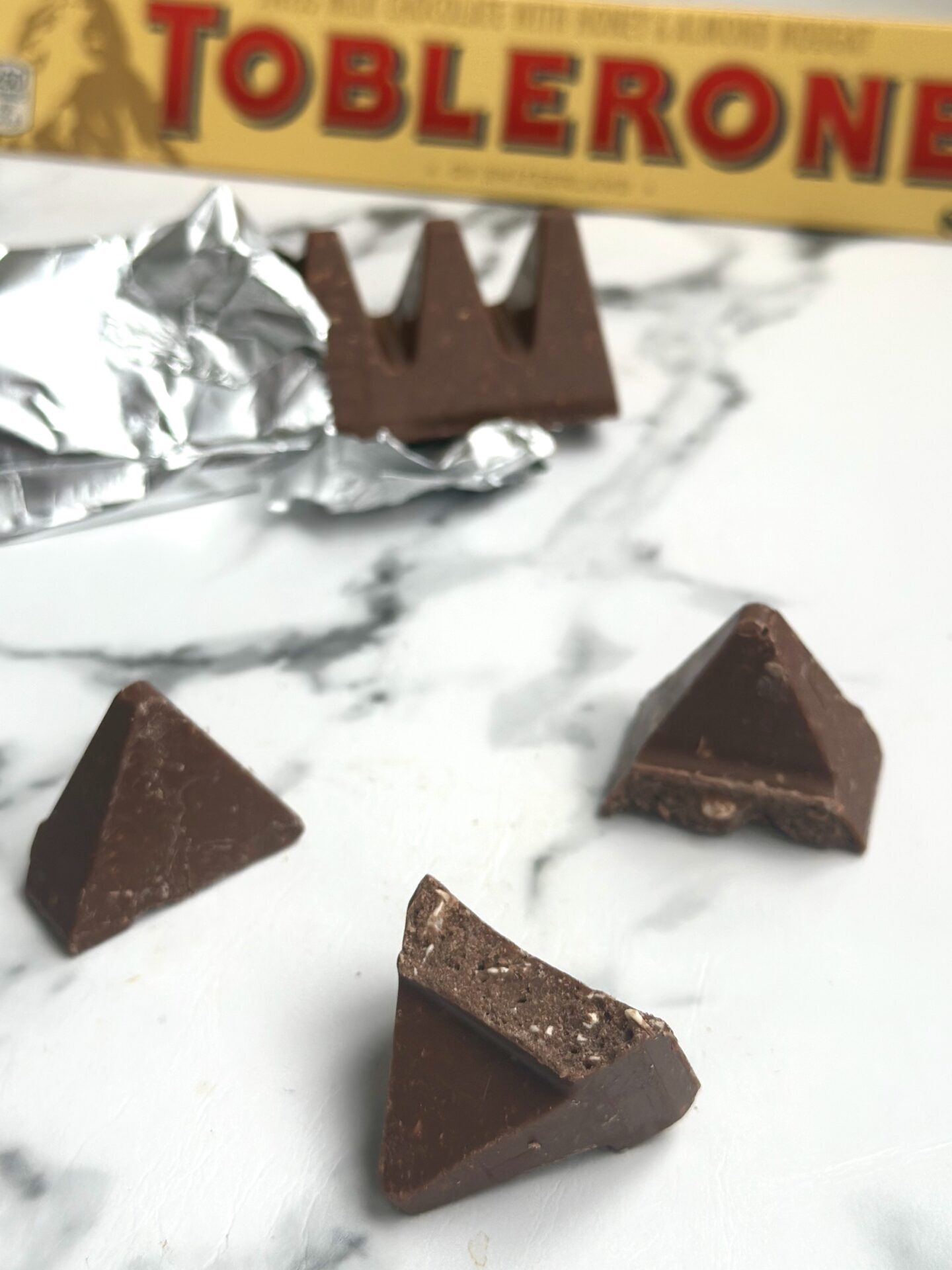 Toblerone chocolate is seen in the package, as a whole bar and broken into pieces