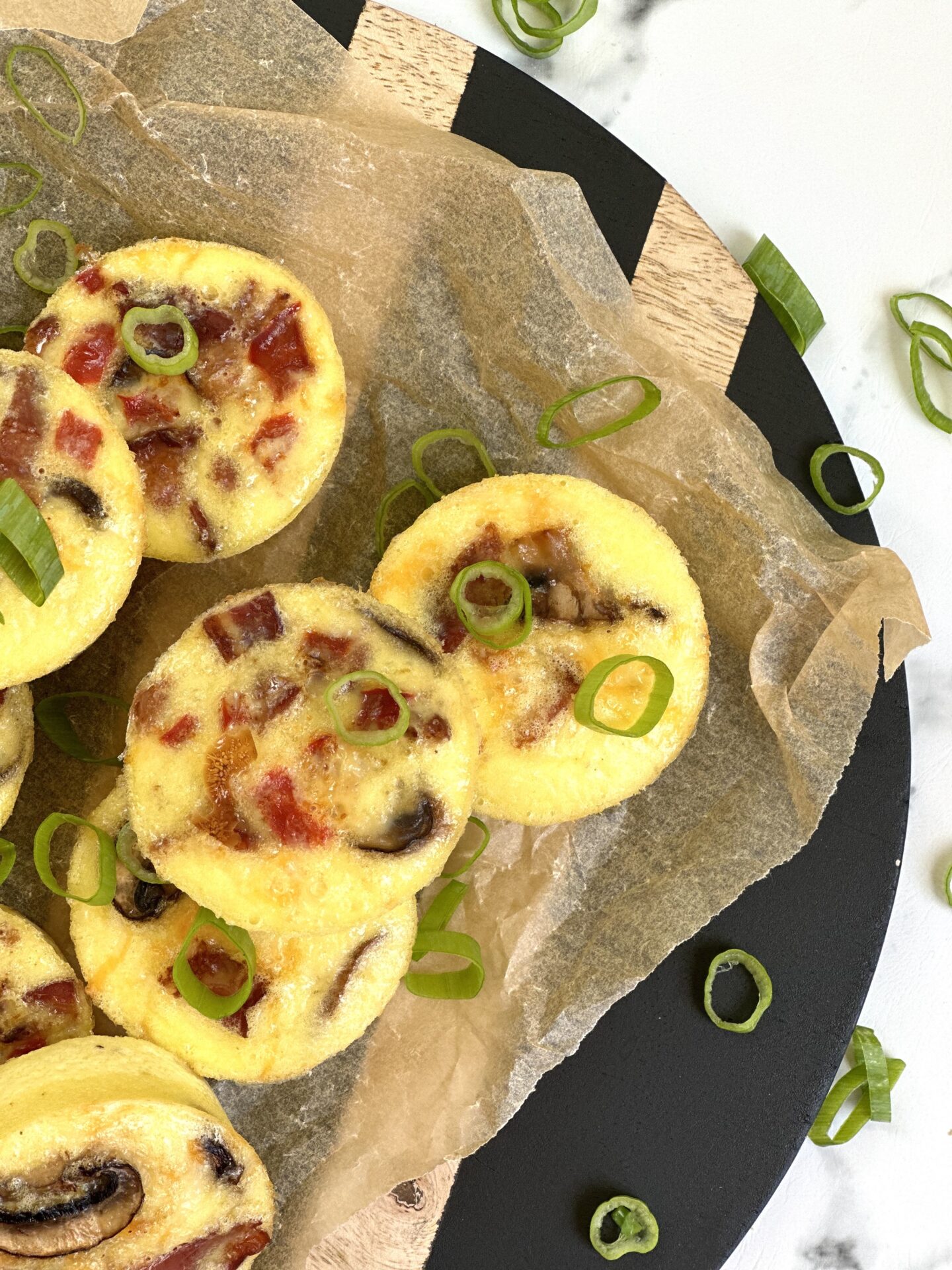 Oven baked egg bites are seen from above garnished with sliced green onions