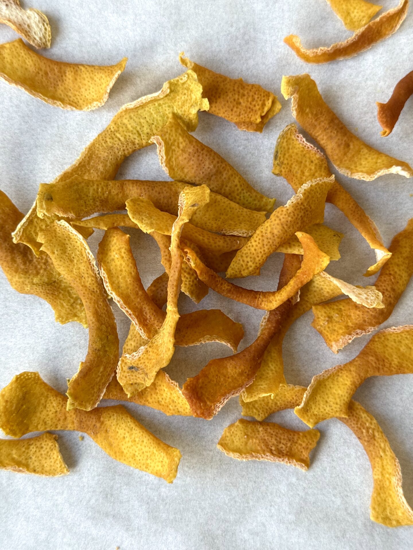 A pile of dehydrated strips of lemon zest are seen from above